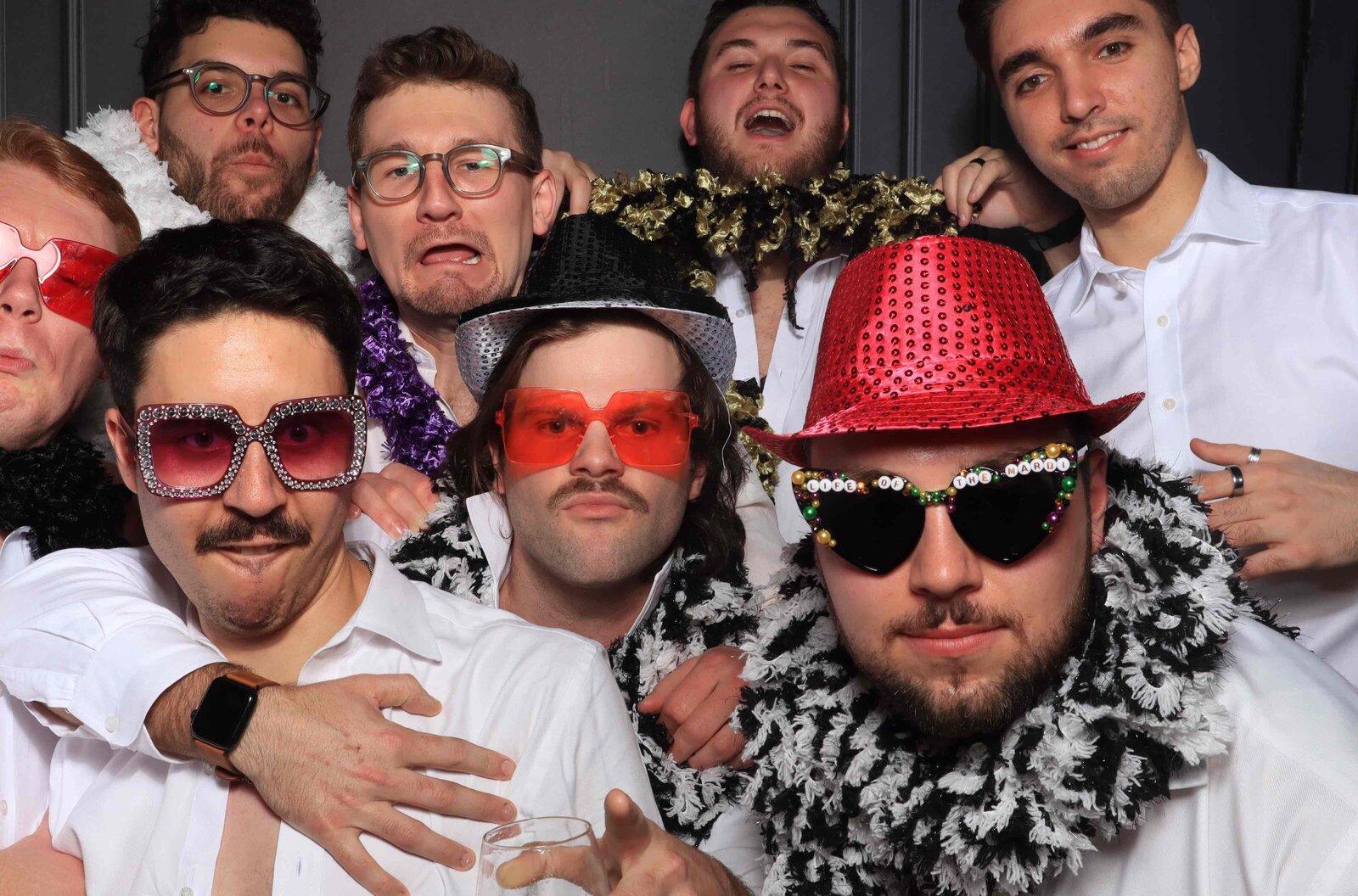 Group of friends in sunglasses and hats in the photo booth